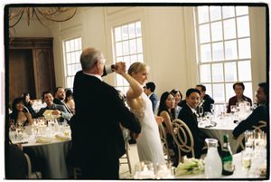 A panoramic view of an elegant wedding reception setup in a bright, window-lit room with dining tables.
