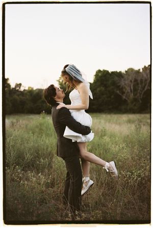 A romantic couple embraces in a golden field at sunset, creating a dreamy silhouette against the natural backdrop.