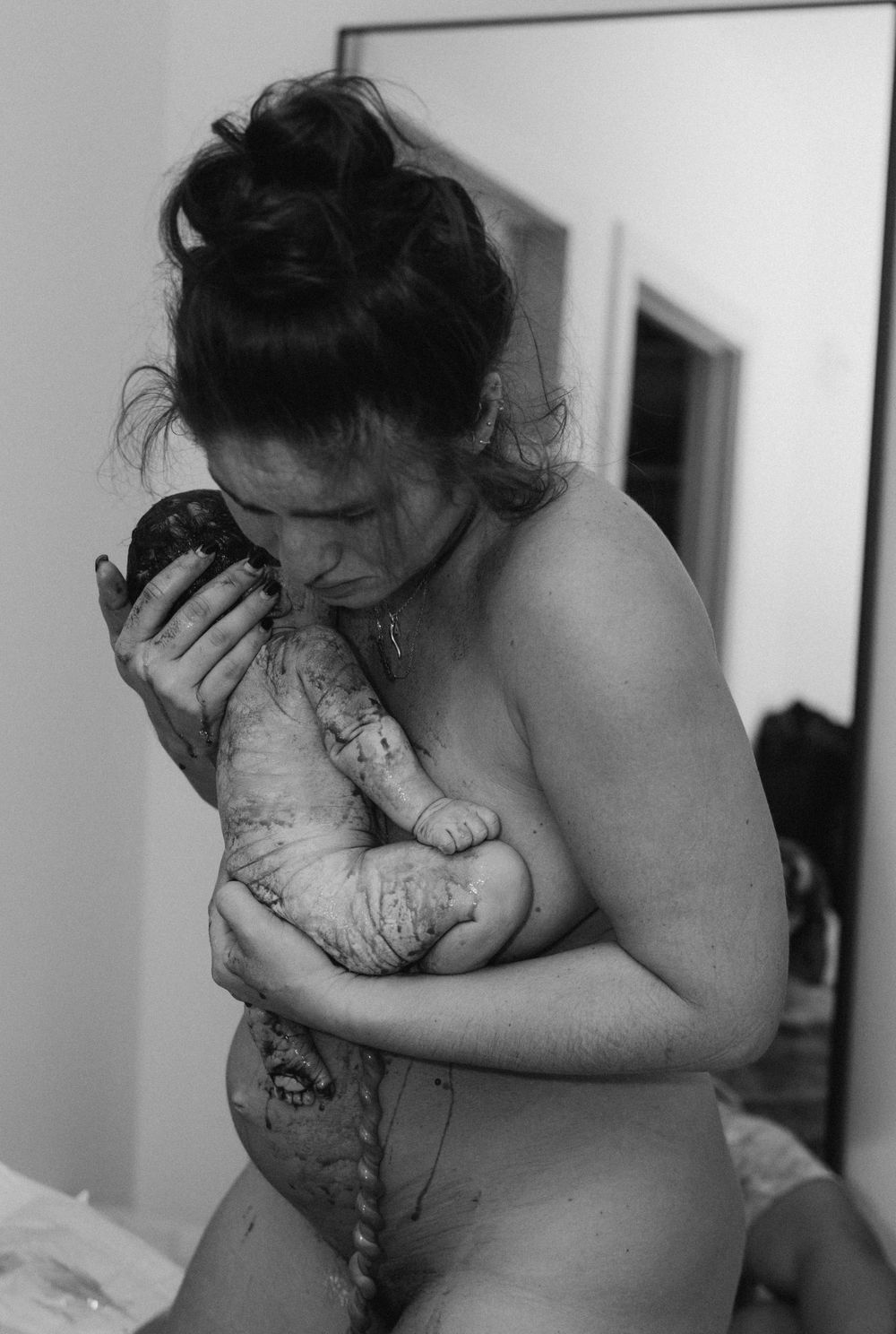 bringing her baby up to her chest