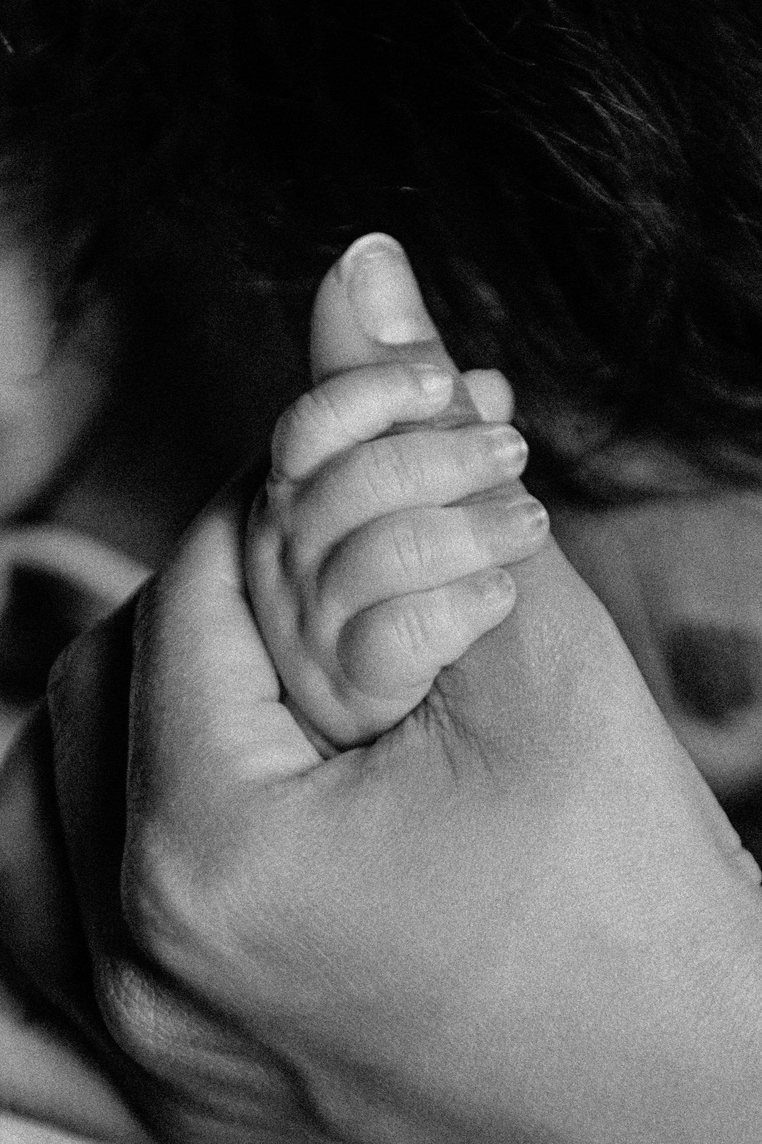Black and white macro shot of tiny baby hand details.