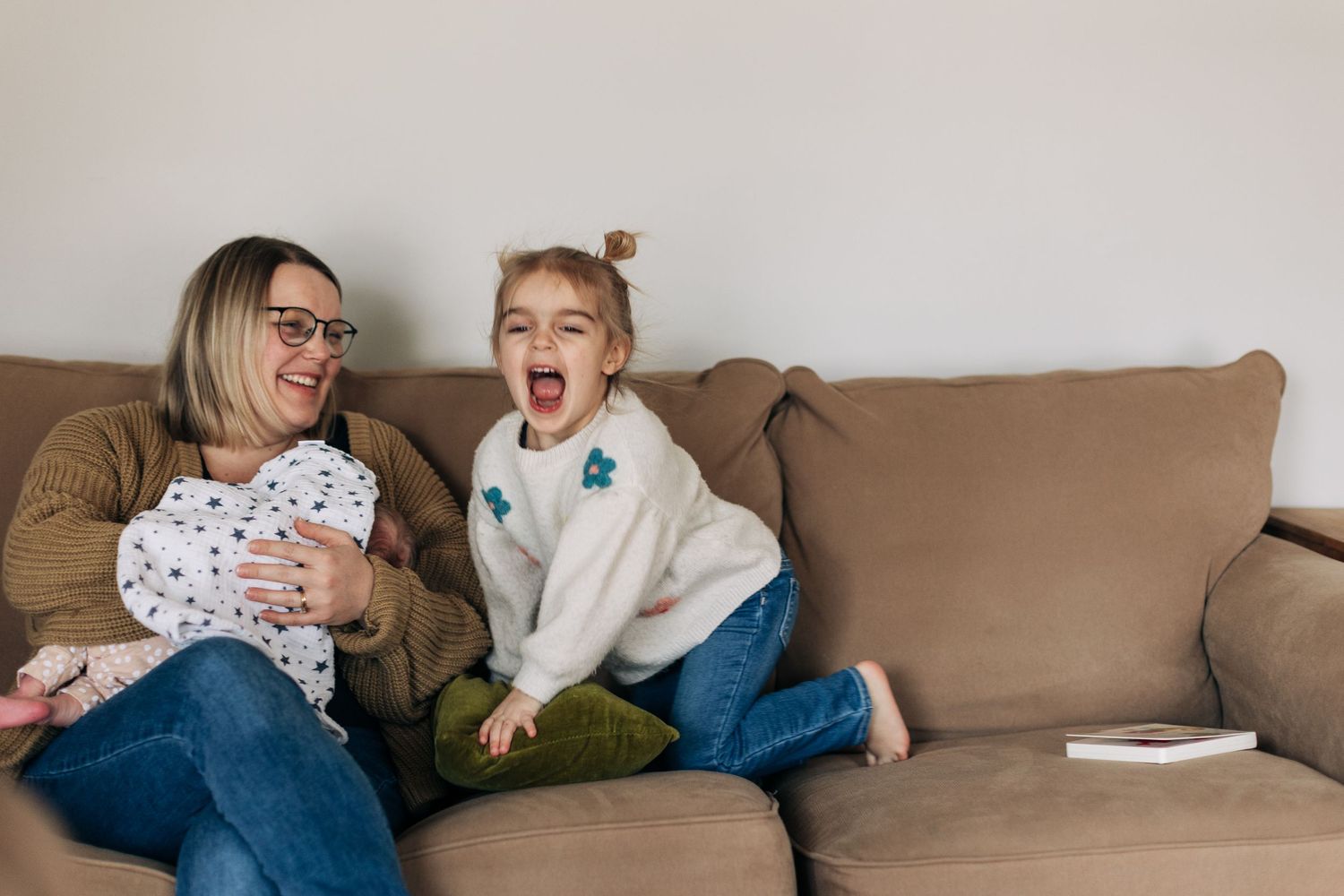 A joyful family moment shared on a comfortable brown couch.