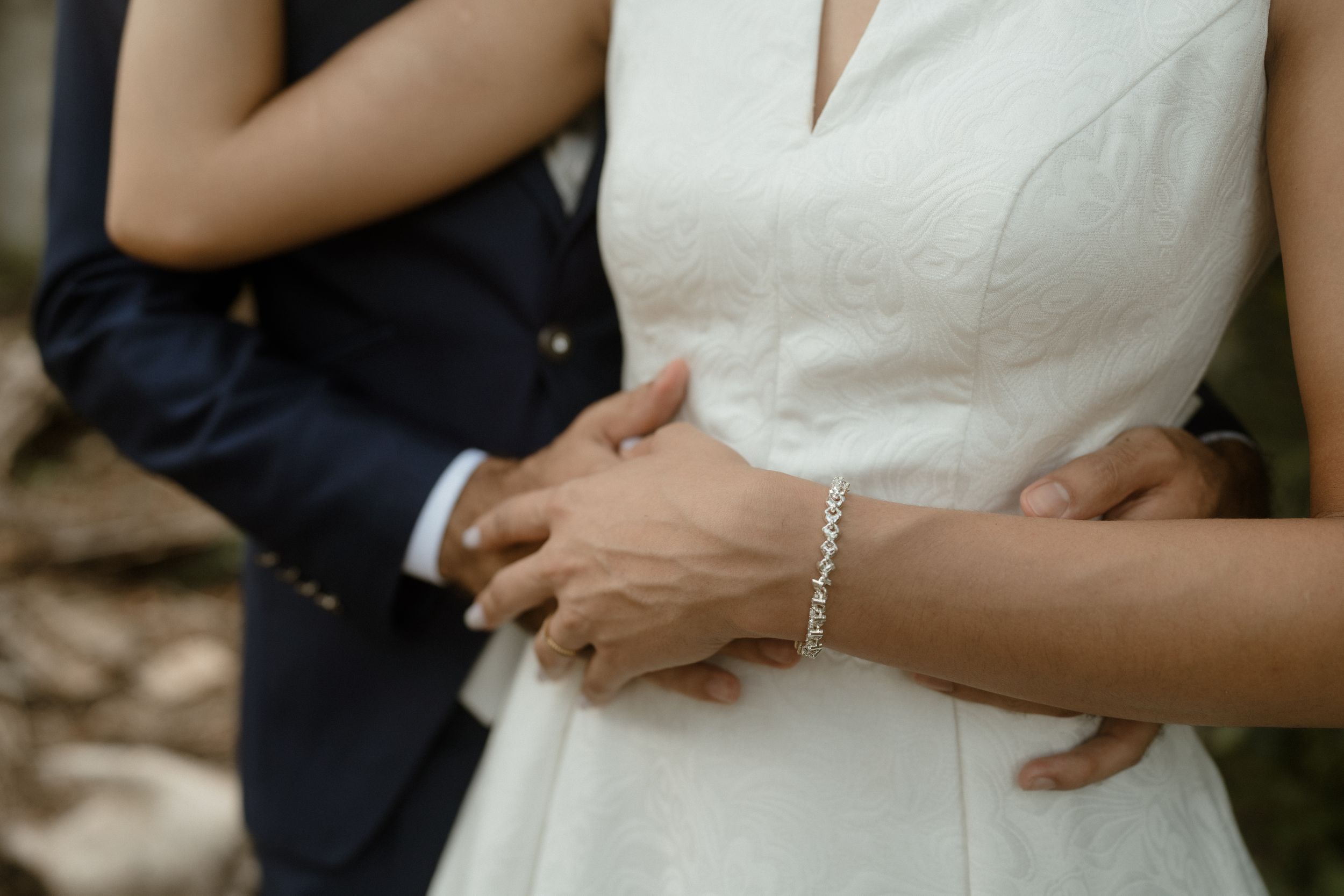 Intimate wedding couple moments captured against a backdrop of green leaves.