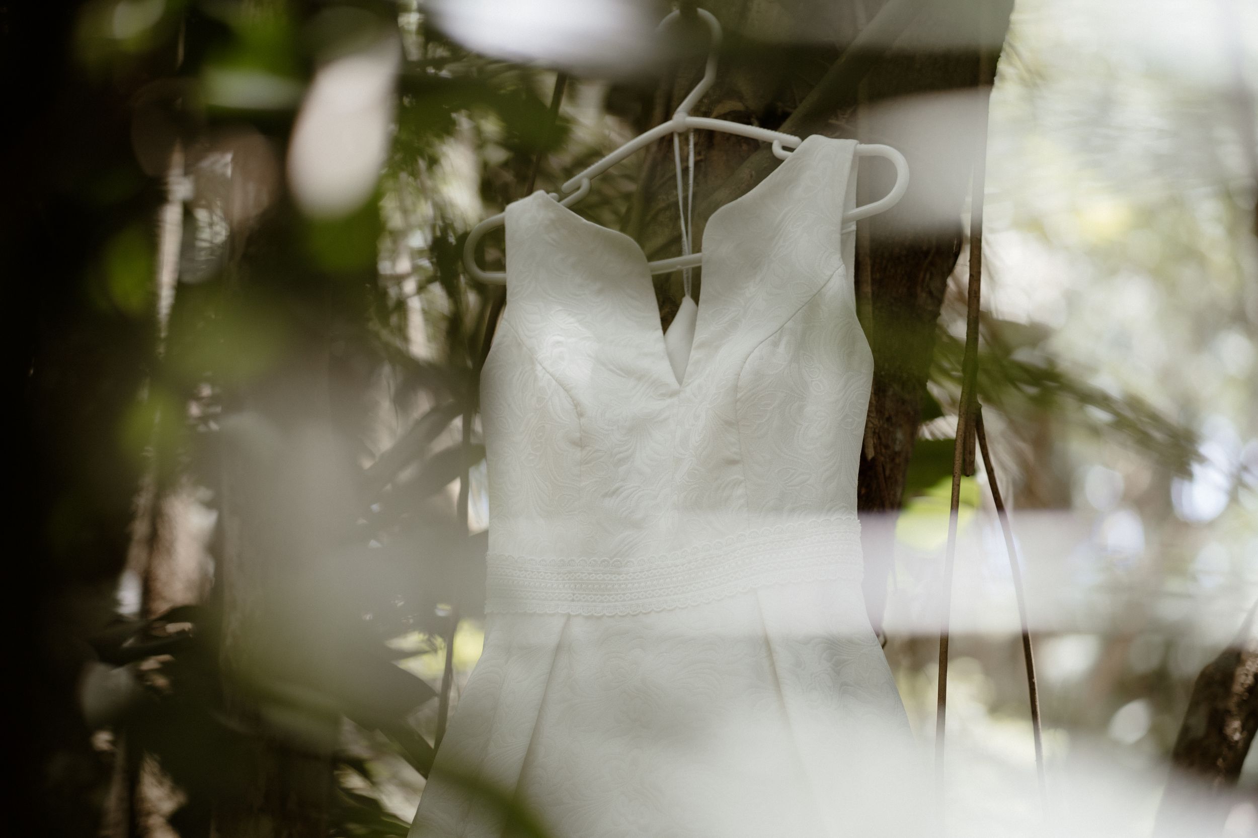 Ethereal white fabric flowing in soft focus against a natural background.