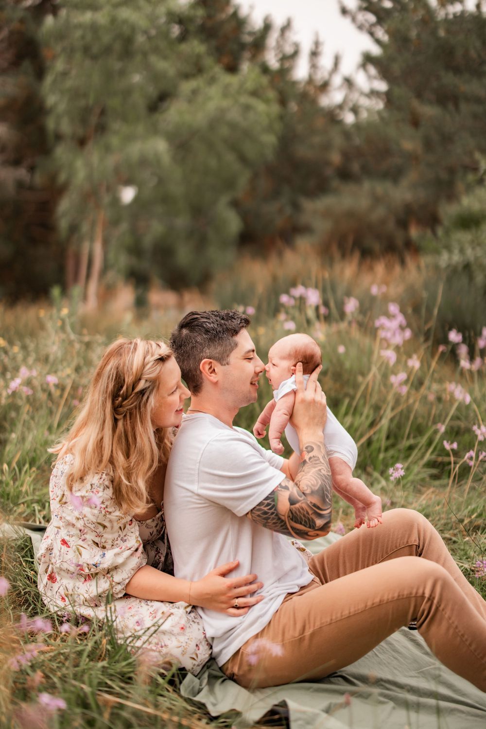 Family enjoying a peaceful moment together in a meadow with purple wildflowers.