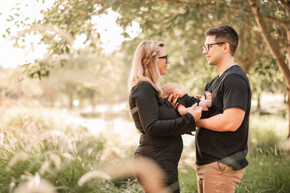 Couple sharing a special moment together in a sunlit field with tall grass.