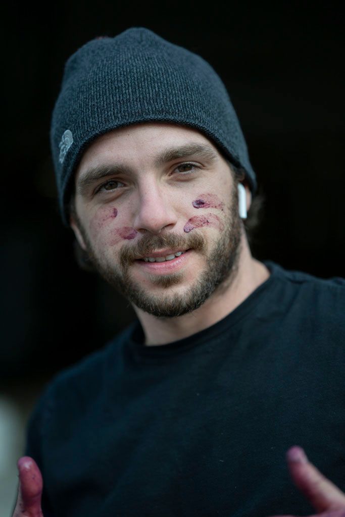 Person wearing dark beanie smiles warmly at camera.