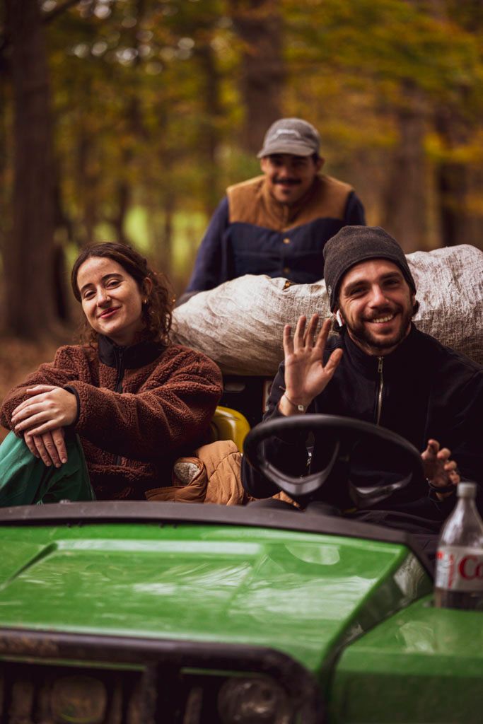Group enjoying an autumn day on a green utility vehicle in the woods.