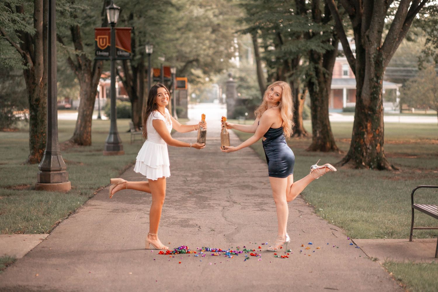 Dance photo session on campus walkway with playful jumping poses.