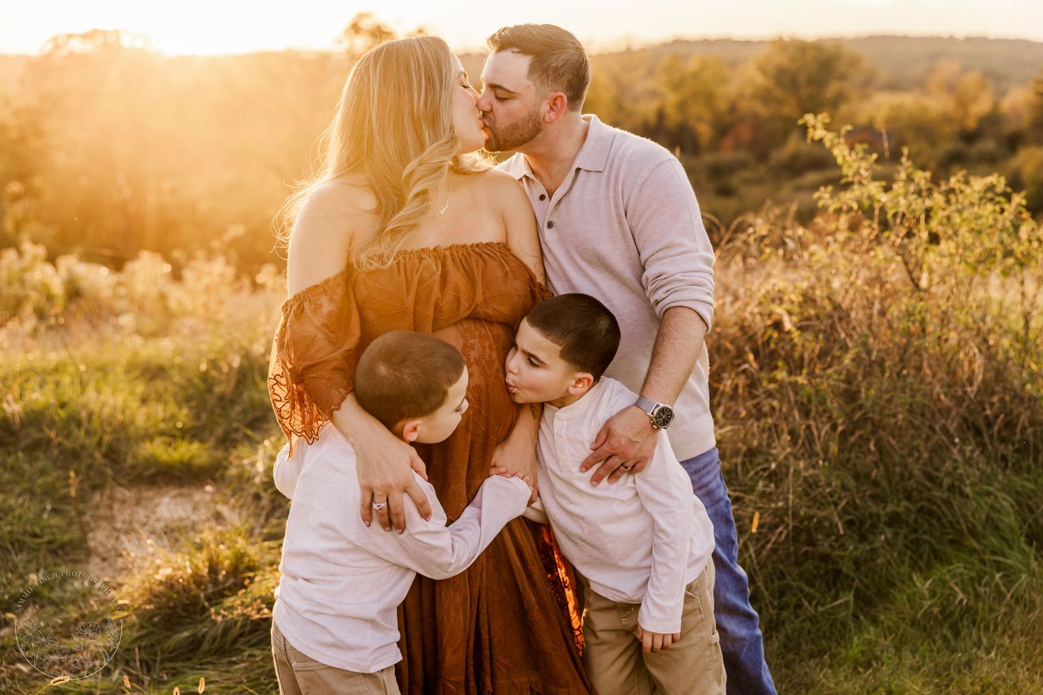 A family sits together under blooming cherry blossom trees in a spring outdoor photo session.