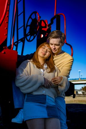 Couples posing next to a red train car in Old Town Petersburg Virginia, portrait taken by Chris Suits Photography