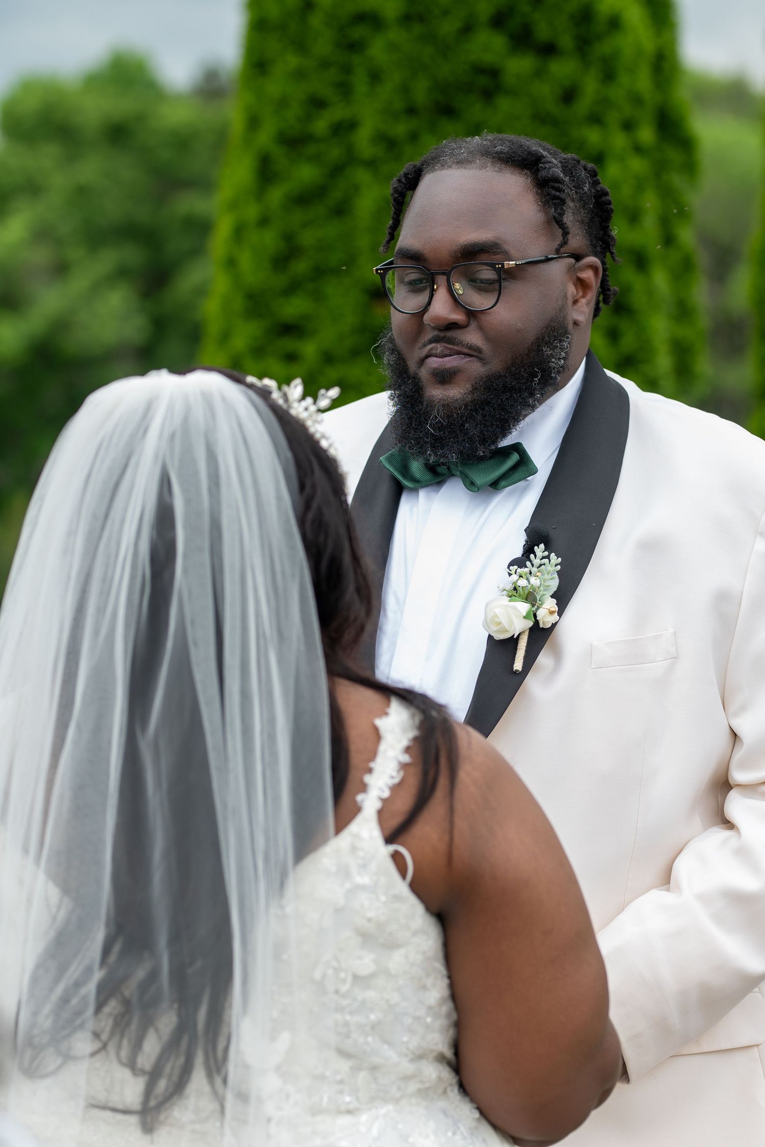 Intimate moment between bride and groom during garden wedding ceremony.