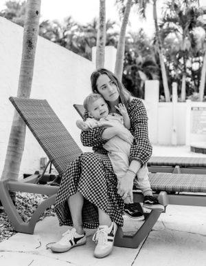 A relaxing moment on a poolside lounge chair under palm trees on a sunny day.
