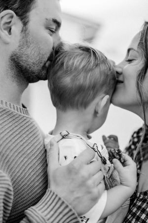 An intimate black and white portrait capturing a tender moment of family affection.