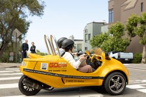 two tourist ridding a small rented car to tour San Fransisco California "go car tours"