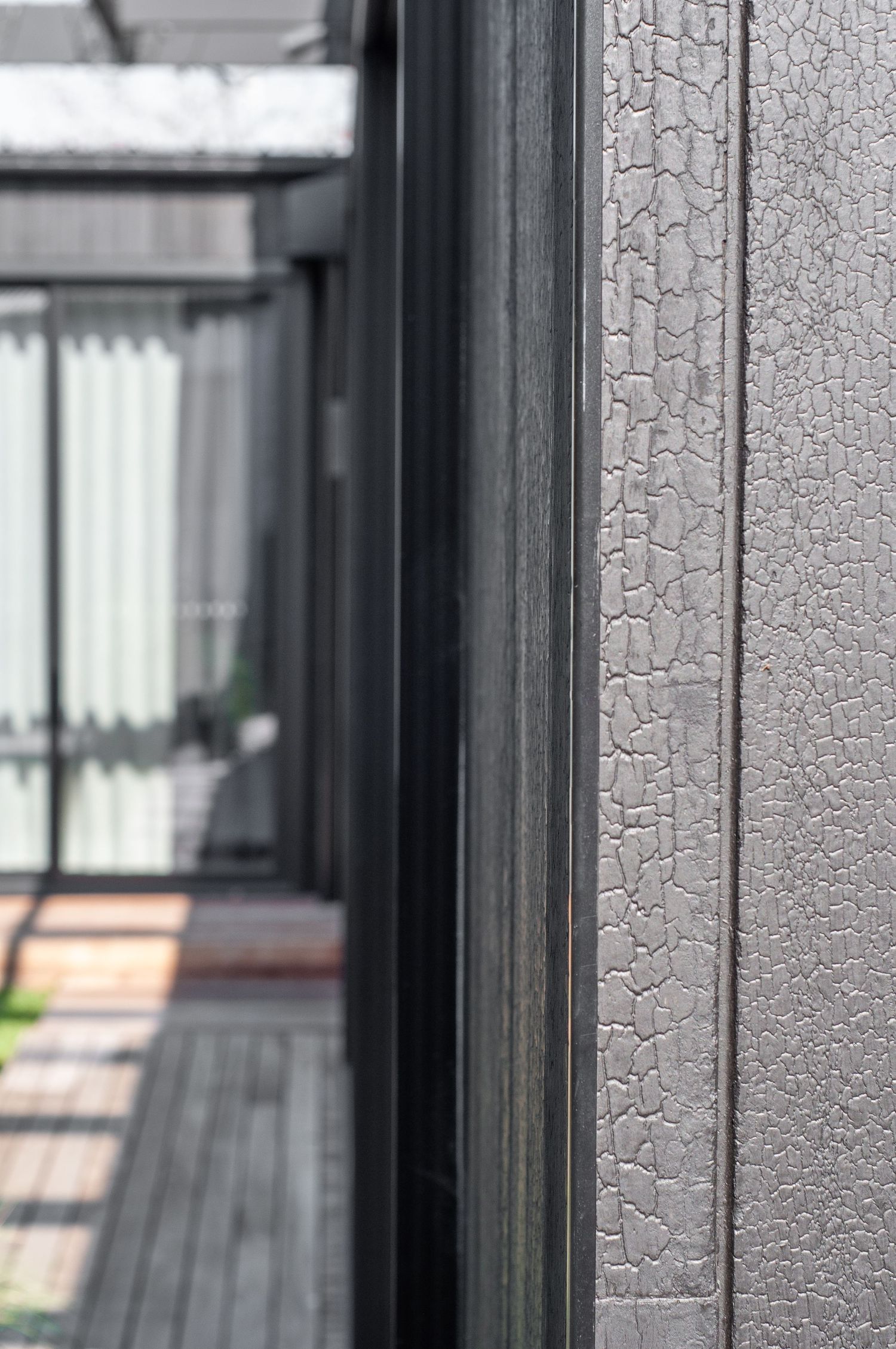 Close-up of black frame and textured wall detail in modern architectural design.