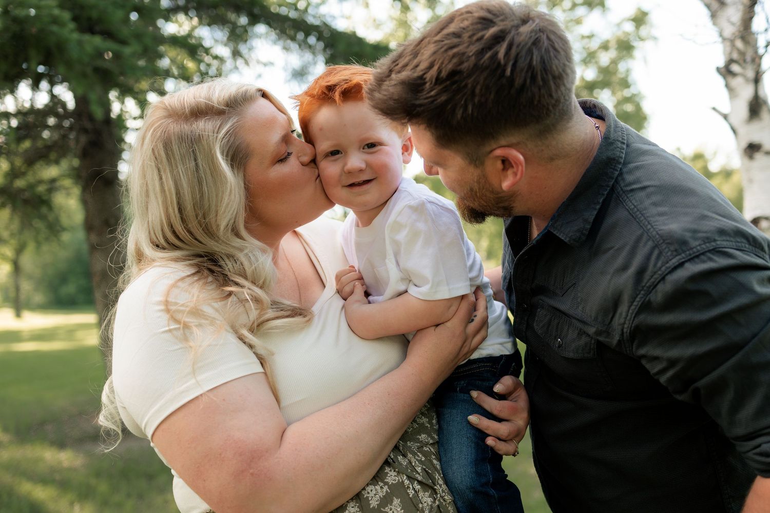 Family portrait session in a grassy field showing playful moments together.