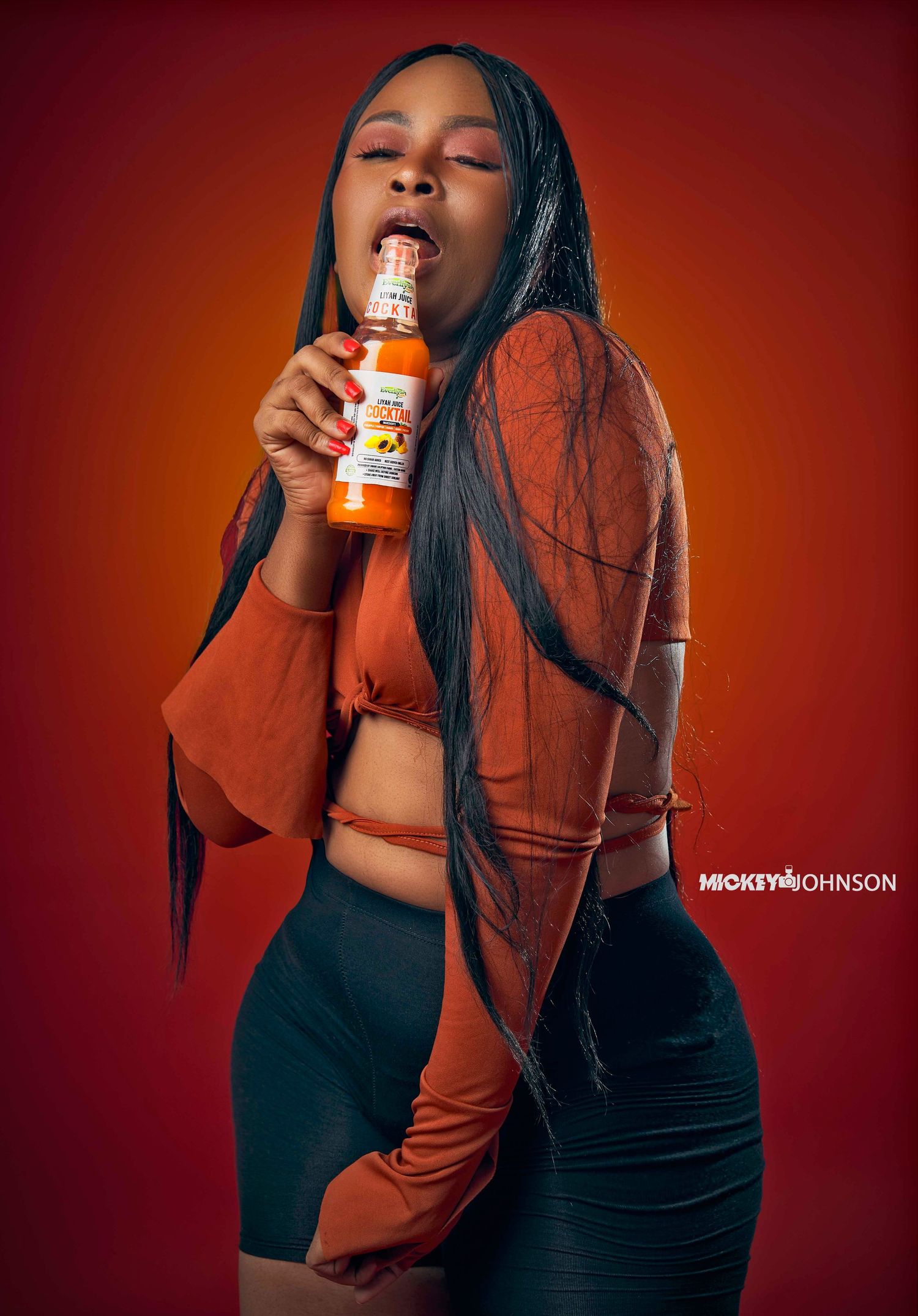 Stylish photoshoot featuring a dark orange jacket against a deep red background.