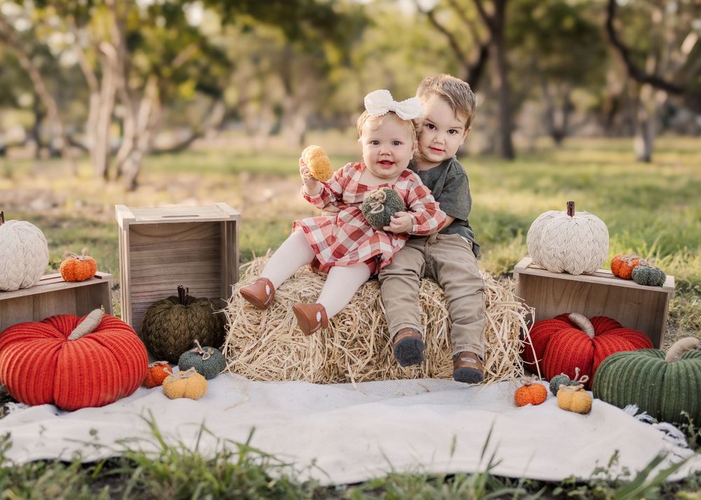 Fall harvest scene with pumpkins and hay bales creates cozy autumn photo setting.