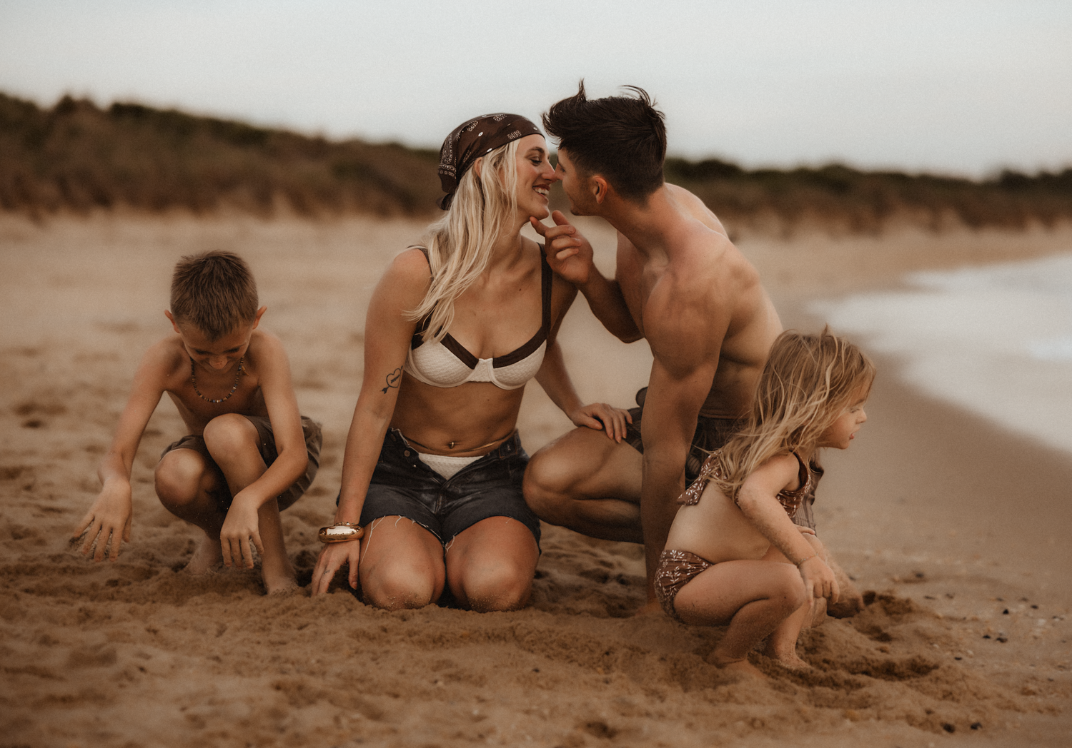 Playful outdoor family session with flowing fabric in sepia tones.