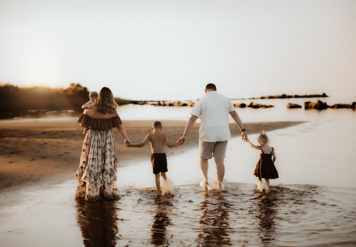 Playful outdoor family session with flowing fabric in sepia tones.