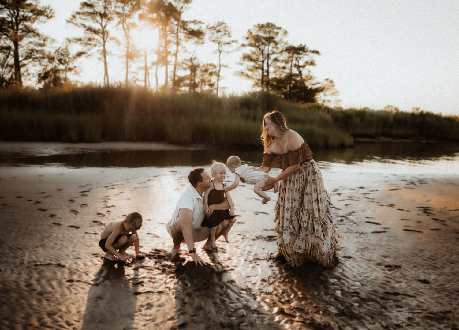 Playful outdoor family session with flowing fabric in sepia tones.