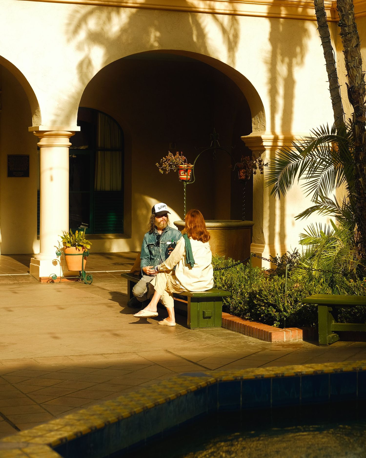 a couple in a San Diego park sitting on a bench and having an intimate conversation