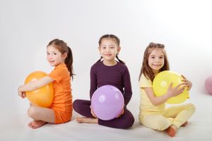 Studio portrait featuring colorful balloons against a white backdrop during a playful session.