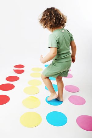 A playful scene with colorful dots arranged on a white floor.