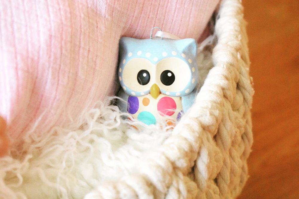Cute owl plush toys with big eyes against a pink textured background.