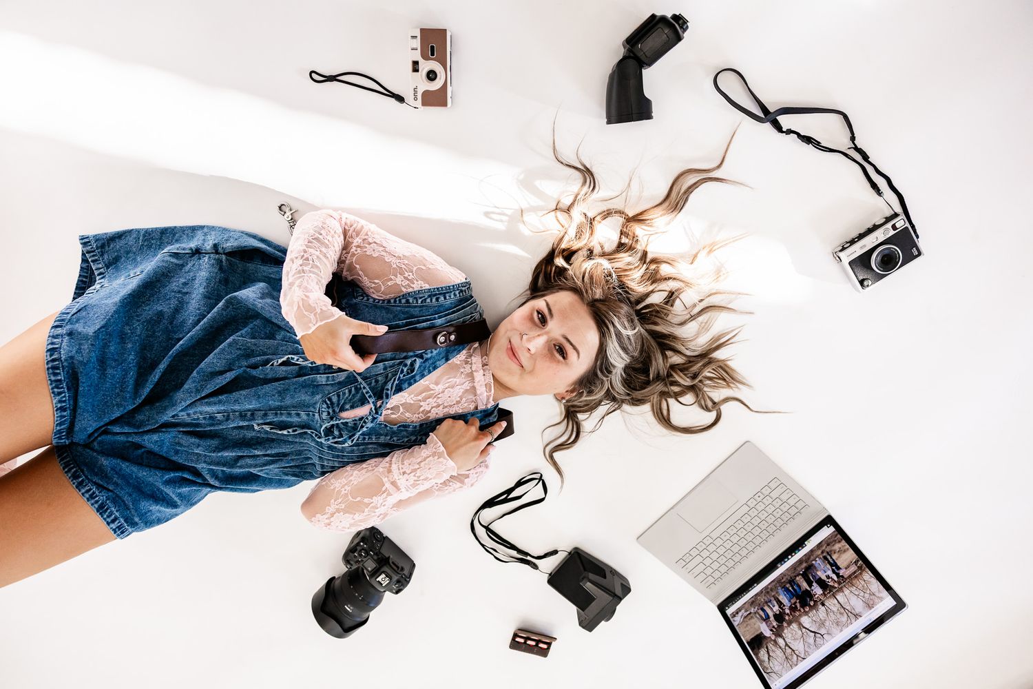 Wyoming Photographer
Overhead view of a photographer lying on white background surrounded by camera equipment and accessories.