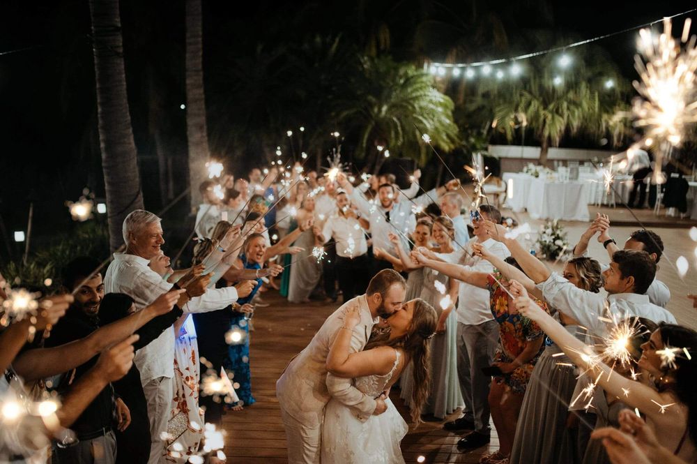 Wedding couple kissing while guests hold sparklers during a Costa Rica celebration
