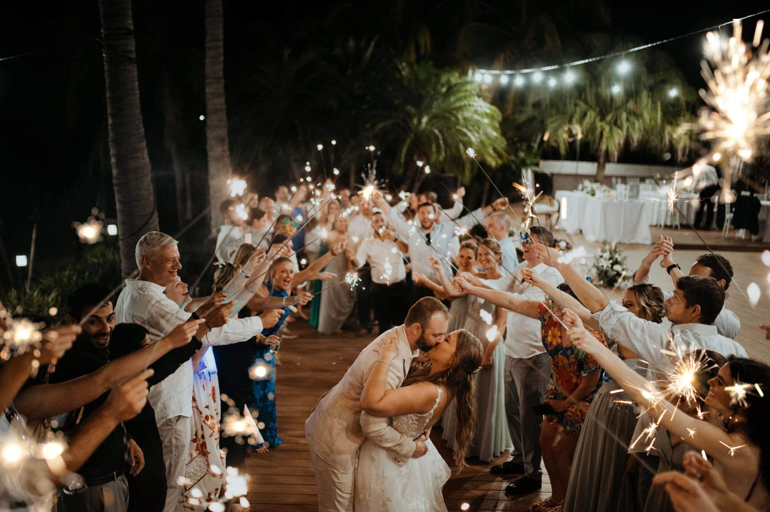 Wedding couple kissing while guests hold sparklers during a Costa Rica celebration