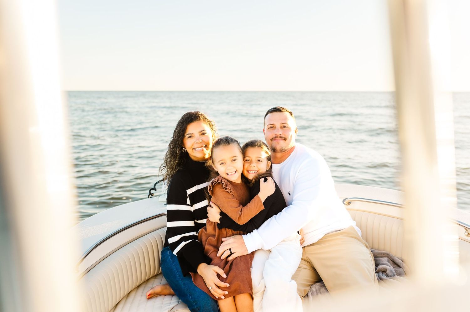 Family enjoying a relaxing boat ride together on the water at sunset. PRESLEY ROSE PHOTOGRAPHY OCEAN ISLE BEACH SUNSET BEACH BRUNSWICK BEACH