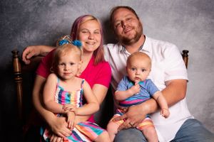 Family pose in front of backdrop