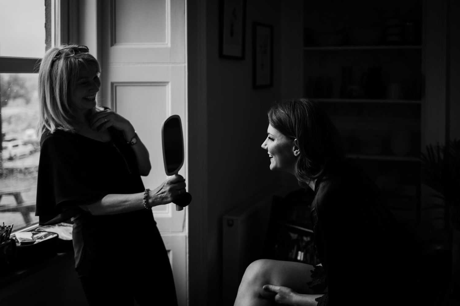 Two people having an animated conversation in a dimly lit room.