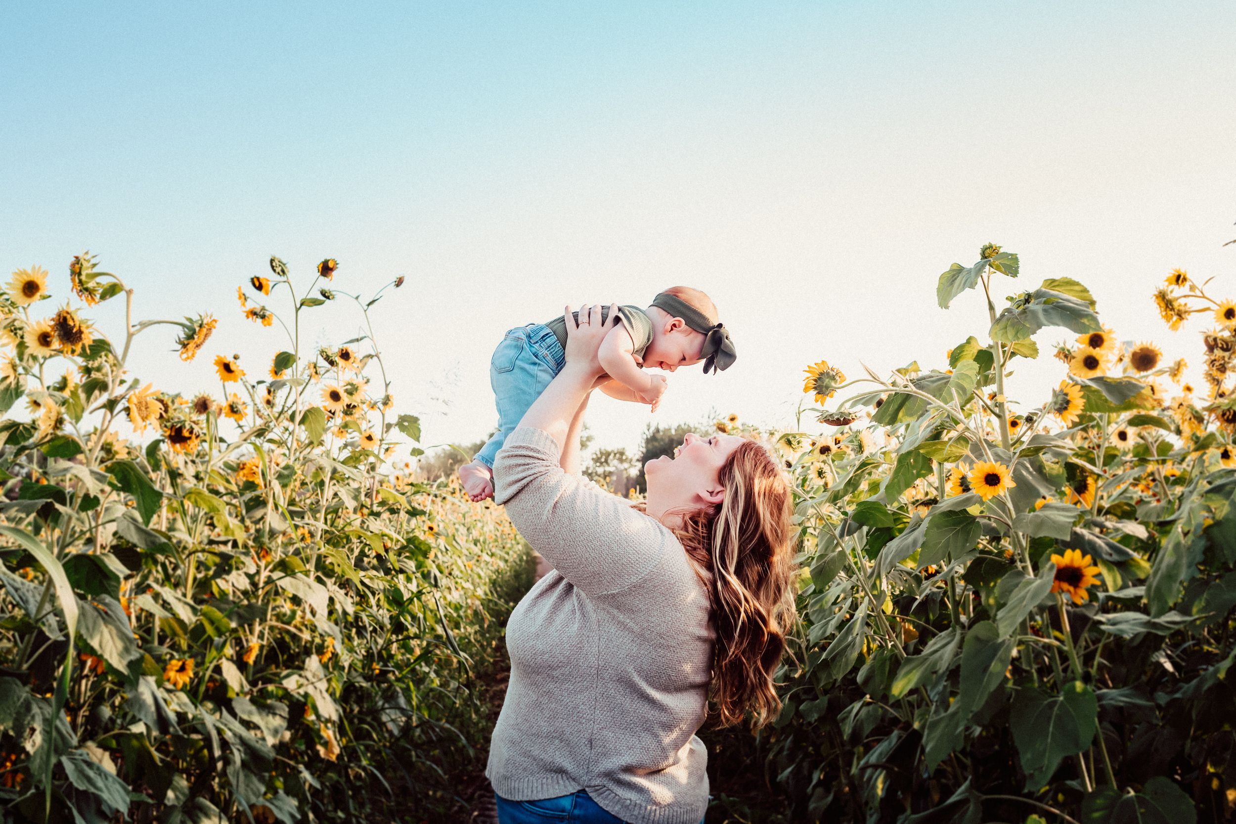 Joyful moment in a sunflower field during golden hour.