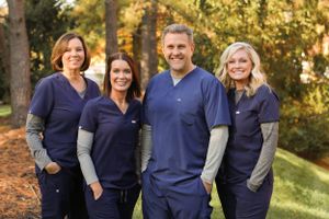 Medical team in navy uniforms posing outdoors.