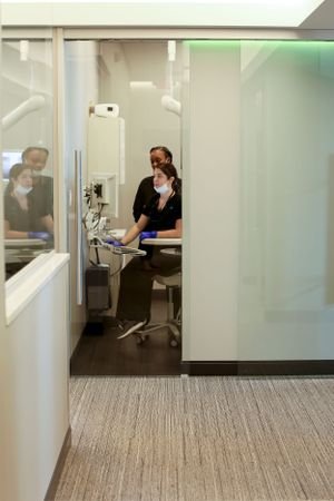 Interior view of a modern dental examination room with equipment and seating.