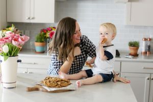 Cozy kitchen scene with fresh flowers, baked cookies, and family bonding moments on the counter.