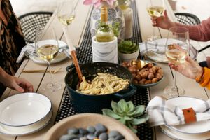 Table spread with pasta, wine, and dishes during a casual dining gathering.