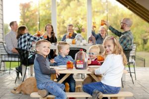 Group gathering for an outdoor meal on a covered patio.