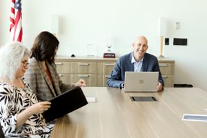 Professional meeting in conference room with laptop and American flag.