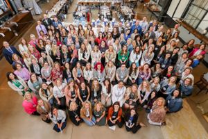 Large group photo of attendees gathered together at a professional conference in an indoor venue.