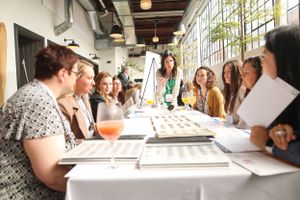 Group seated around tables during a creative workshop or meeting in bright industrial space.