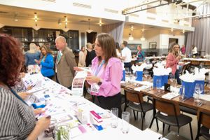 Attendees participating in activities at tables during a professional conference workshop.