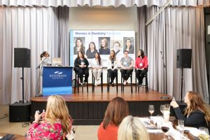 Panel discussion taking place on stage at a professional conference with audience members watching.