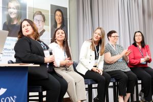 Group of professionals participating in a panel discussion on stage at an industry event.