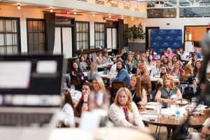 Audience members listening attentively during a professional conference presentation.