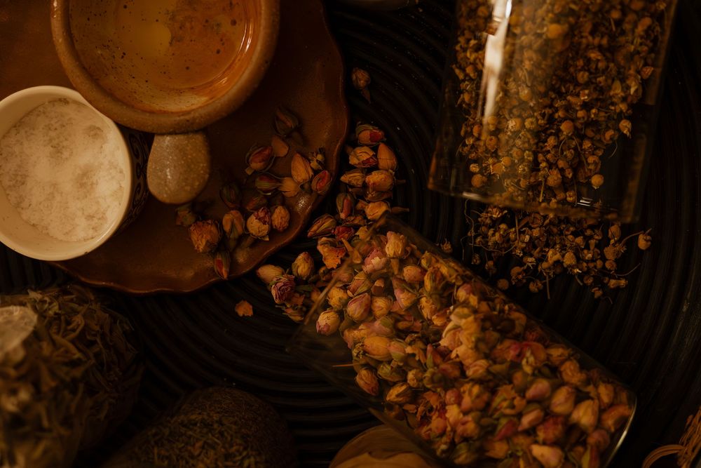 Dark moody still life with scattered nuts and earthenware pottery in rustic setting.