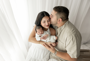 Family posed newborn photoshoot in lifestyle studio.